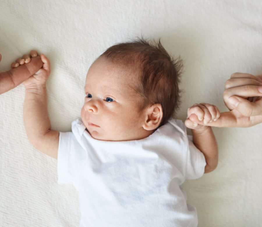 Baby, das Finger der Eltern hält