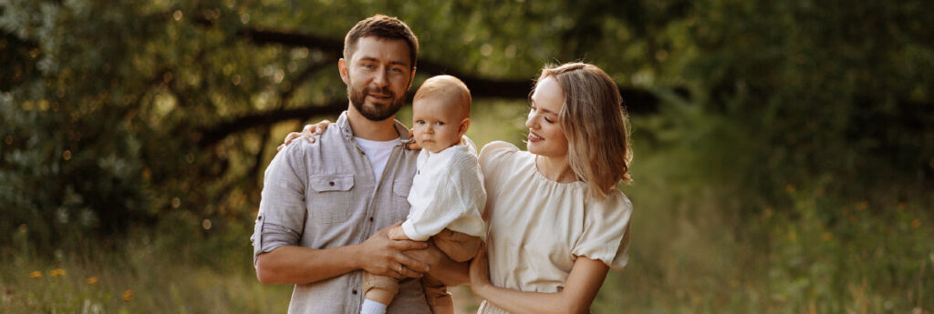 Glückliche Eltern mit Baby auf dem Arm